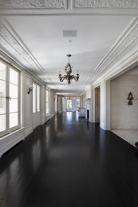 Grand hallway corridor, antique lighting fixtures, dark wood floors, double white 4 lite oversized windows Ebony Wood Floors, Dark Floors Light Walls, Surrey Mansion, Dark Hardwood Floors Living Room, Hallway 2023, Dark Wainscoting, Dark Oak Wood Floors, Black Hardwood Floors, Dark Timber Floors