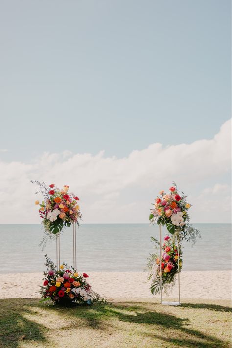 Beach wedding at Palm Cove (North Queensland). Bright, colourful floral plinths created by I Do Flowers Cairns. Stunning backdrop to our intomate, lunchtime wedding. Colourful Flower Arch Wedding, Wedding Plinths Ceremony, Floral Plinths, Flower Plinth, Pond Wedding Ceremony, Beach Wedding Florals, Plinth Flowers, Brazil Flowers, Brazil Wedding