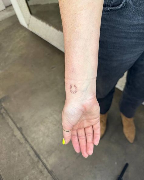 Minimalistic style horseshoe tattoo done on the wrist. Small Horshoe Tattoo, Horseshoe Wrist Tattoo, Horseshoe Hand Tattoo, Small Horse Shoe Tattoos, Fine Line Horseshoe Tattoo, Tiny Horseshoe Tattoo, Dainty Horseshoe Tattoo, Tiny Horse Tattoo, Horseshoe Tattoo Small