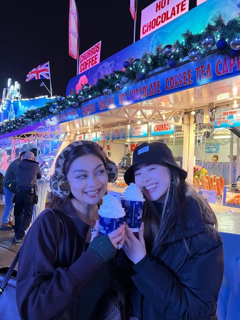 Two Asian girls best friends spending Christmas in winter wonderland holding a hot chocolate and smiling London Christmas Instagram, Winterwonderland London Outfit, Winter Wonderland London Outfit, Winter Photos Friends, Christmas Market Instagram Pictures, London Best Friends, London Instagram Pictures Winter, Winter Wonderland Aesthetic London, Winter Wonderland Outfit London