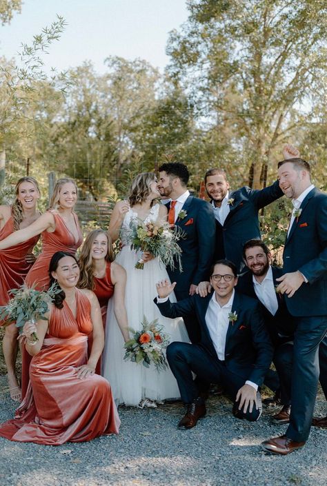 We love the look of this wedding party! The mix of the rusty orange bridesmaid dresses in different styles mixed with the classic navy suits of the groomsmen was the perfect look for this rustic fall vineyard wedding. Dark Teal And Rust Orange Wedding Groomsmen, Rust Orange Bridesmaid Dresses With Groomsmen, Rusty Orange Bridesmaid Dresses, Terracotta Bridal Party, Navy And Rust Wedding, Terracotta And Navy Wedding, Groomsmen Attire Navy Blue, Rusty Orange Wedding, Terracotta Wedding Party