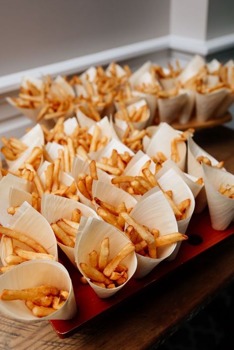 this french fry bar is set up with small paper cones of french fries, which are in boardwalk style french fry holders Party Snacks Wedding, Fries Bar Wedding, Fries At Wedding, Midnight Snack At Wedding, Cocktail Wedding Food Ideas, French Fry Wedding Bar, Reception Treat Ideas, Wedding Fast Food Bar, Wedding Food Late Night