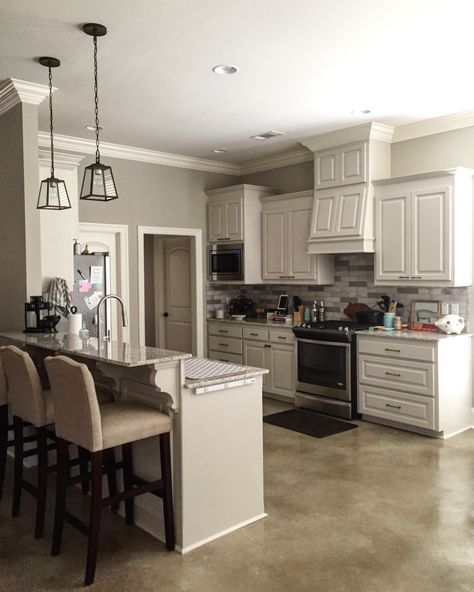 The wall color is Benjamin Moore Revere Pewter (HC-172); the cabinets are Benjamin Moore Edgecomb Gray (HC-173); the trim is Benjamin Moore White Dove (OC-17) | Travertine tile backsplash - I painted the darker tiles in Clark+Kensington Baby Elephant (3052) | 2cm Giallo Ornamental granite | Revere Pewter Cabinets, Pewter Cabinets, Revere Pewter Kitchen, Trendy Farmhouse Kitchen, Revere Pewter Benjamin Moore, Selling Ideas, Revere Pewter, Kitchen Paint Colors, Mobil Home