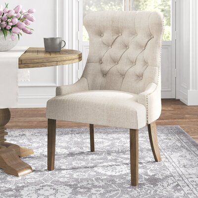 Nailhead trim and a standout silhouette give this side chair a classic look that's ideal for living rooms in traditional and French country homes alike. It showcases a modified wingback silhouette, with sloping recessed arms, tufted back, and a tight seat, making this a crisp addition to your space. It's upholstered with fabric in a neutral hue, so you're able to match this chair with a variety of styles and color palettes in your living or dining room. Upholstery: Heathered Beige Linen | Alcott French Country Homes, Kelly Clarkson Home, Upholstered Side Chair, Kelly Clarkson, French Country House, Upholstered Arm Chair, Laurel Foundry Modern Farmhouse, Accent Chairs For Living Room, Wingback Chair