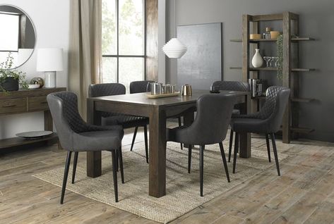 Bring a modern touch to your kitchen or dining room with the Bentley Designs Turin Dark Oak 6-8 Seater Dining Table & 6 Cezanne Dark Grey Faux Leather Chairs with Sand Black Powder Coated Legs. Made with rustic oak veneers set in solid American oak frames in a rich dark oiled finish, the Turin Dark Oak Dining Range successfully creates a striking and bold aesthetic. Dark Oak Furniture, 10 Seater Dining Table, Grey Leather Chair, Oak Extending Dining Table, 8 Seater Dining Table, Blue Velvet Chairs, Bentley Design, 6 Seater Dining Table, Faux Leather Chair