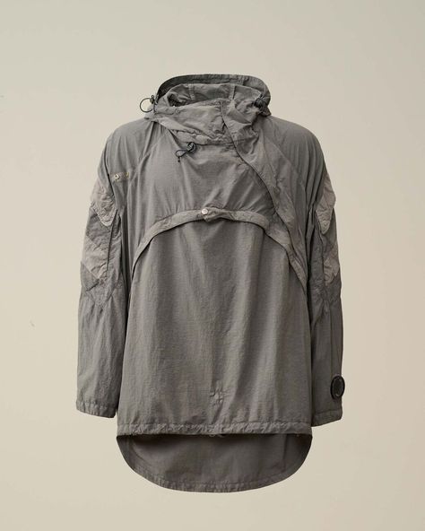 Hooded transformable jacket from C.P. Company and Kiko Kostadinov's second collaboration, crafted in Flatt Nylon, an emerized opaque nylon, mixed with Mais gabardine. Detachable front opening, convertible into a shoulder zipped bag. Diagonal zip fastening can be modified into a hidden fastening with velcro straps. Shoulder flap pockets. Garment dyed. Designer Athleisure, Fit Moodboard, Dots To Lines, Kiko Kostadinov, Country Shop, C P Company, Blazer Shirt, Zipped Bag, Velcro Straps