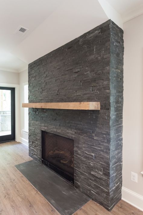 Black stacked stone fireplace with reclaimed natural wood mantel in walk out basement of of custom home by BCN Homes in Arlington, Virginia Black Stacked Stone Fireplace, Split Face Tiles, Stacked Stone Fireplace, Stacked Stone Fireplaces, Tiles Uk, Wood Mantel, Tile Cladding, Home Furnishing Stores, Wood Mantels