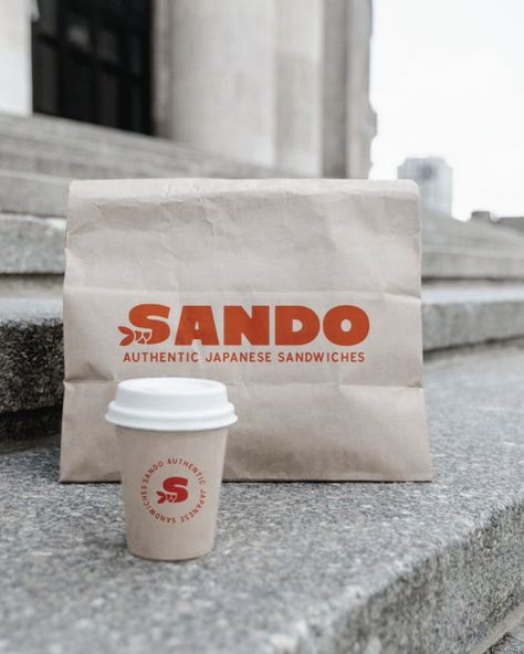 Sando is a sandwich shop founded by a Japanese American family with a deep passion for creating delicious, culturally rich sandwiches. Their mission is to blend traditional Japanese flavors with the classic American sandwich, offering a unique and memorable culinary experience.   Brand identity design, poster design, logo inspiration, food branding, restaurant visual identity, aesthetic branding, red and yellow color themes, bold minimalism Japanese Cafe Logo, Sandwich Shop Aesthetic, Sandwich Shop Branding, Japanese Bakery Logo, Sandwich Shop Design, Restaurant Visual Identity, Identity Aesthetic, Sandwich Logo, Japanese Flavors