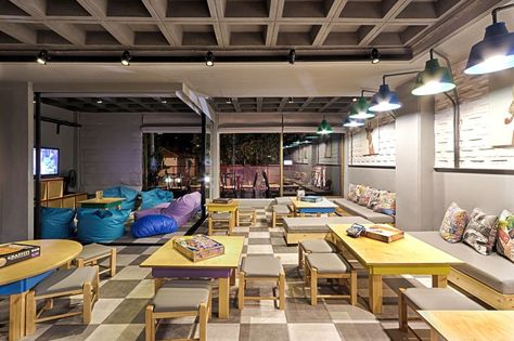 Love the separate beanbag seating area in this board game cafe and bar. Games Cafe, Board Game Bar, Gaming Cafe, Cat Gaming, Game Bar, Board Game Cafe, Painted Brick Walls, Gaming Center, Game Cafe