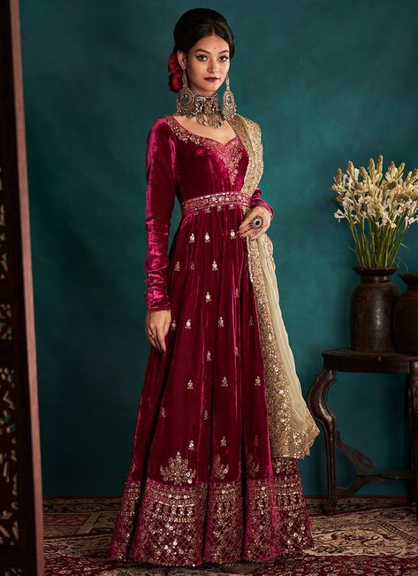 Dress to impress with this our Magenta and Gold Embroidered Velvet Anarkali.  The magenta velvet pishwas has been pleated with kashmiri style embroidered detailing of tilla and dabka in a scintillating shade of muted gold hue. The transition of small booties into big eloborate motives transcending into an abundantly wo Churidar Pajama, Indian Suits For Women, Heavy Dupatta, Pakistani Wedding Dresses, Anarkali Dress, Frock Design, Fashion Attire, Pakistani Bridal, Indian Wedding Dress