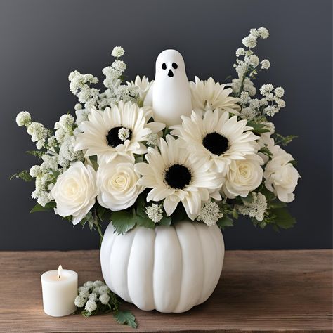 White Pumpkin Flower Arrangement with Ghost Accent Give the gift of everlasting silk flowers this fall with our enchanting ghostly fun flower arrangement in a charming pumpkin, complete with a playful ghost accent. This spooky yet sophisticated arrangement features a mix of delicate white blooms, such as roses, lilies, and mums, artfully arranged inside a classic white pumpkin. The subtle ghost detail adds a whimsical touch, making this the perfect centerpiece for Halloween gatherings or autumn celebrations. Whether you're gifting a loved one or adding a festive flair to your home or office for a party, this arrangement brings whimsy and a touch of spooky charm to any gift giving flower arrangement for a birthday or get well flower giving or just because. it’s the perfect choice for those Halloween Silk Flower Arrangements, Halloween Floral Bouquet, White Fall Centerpieces For Table, White Fall Floral Arrangements, Ghost Floral Arrangement, Halloween Floral Design, Fall Pumpkin Flower Arrangements, Flowers In Pumpkins Floral Arrangements, Jackolantern Centerpiece