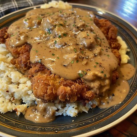 🥩🍴 Dive into the comfort of Chicken Fried Steak with creamy gravy! A true Southern delight. #ComfortFood #ChickenFriedSteak Chicken Fried Steak with Gravy Recipe Savor the crispy coating and tender steak, smothered in a rich, creamy gravy for a classic Southern meal. Ingredients: Beef cube steaks: 4 (about 600g total) All-purpose flour: 150g Eggs, beaten: 2 Milk: 120ml for batter + 240ml for gravy Salt: 5g Ground black pepper: 5g Garlic powder: 5g Vegetable oil for frying Butter: 30g Chic... Chicken Fried Steak And Eggs, Brown Gravy Chicken, Country Fried Chicken And Gravy, Biscuits And Gravy Recipe, Steak With Gravy, Cube Steaks, Steak And Gravy, Southern Dinner, Country Fried Steak