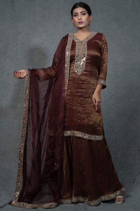 Featuring a brunette brown kurta in soft zari handloom chanderi tissue base with hand embroidery. It is paired with matching sharara pants and a pure organza dupatta.  FIT: Fitted at bust and waist. COMPOSITION: Soft zari handloom chanderi tissue, Velvet, Pure organza. CARE: Dry clean only. Brown Sharara, Fancy Dress Patterns, Hand Embroidered Skirt, Saree Reuse, Mirror Work Embroidery, Kurta And Sharara, Sharara Designs, Indian Sari Dress, Simple Kurti Designs