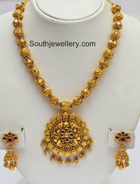 22 carat gold intricate work gundla  mala with attached beautiful flower pendant studded with rubies and emeralds. The necklace is complemented by matching gold jhumkas. Weight: 96 grams Price: Approx 3,20,000 For inquiries contact: info@ vummidi.com Related Posts72 Grams Gundla Mala with Pachi PendantLight Weight Ruby South Sea Pearl NecklaceMango Necklace and Long Gundla HaramGundla Latest Gold Design, Gundla Mala, Gold Jhumkas, Latest Jewellery Designs, Gold Jewelry Outfits, Antique Pins, Gold Chain Design, Gold Necklace Indian Bridal Jewelry, Antique Jewelry Indian