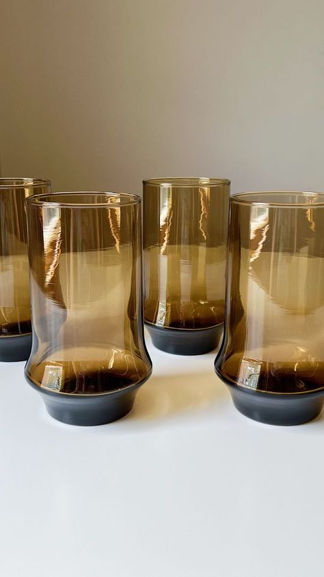 These brown smoked glasses embody the allure and style of the 1970s. The vintage design of these tumblers features sleek lines and a slightly flared shape which exudes an understated elegance that never goes out of style. Whether you're hosting a retro-themed party or simply looking to add a touch of vintage sophistication to your drink collection, these tumblers are sure to impress your guests and transport them back in time. Product Details Year: 1970s Capacity: 16 fluid ounces 70s Dishware, 1970s Glassware, Brown Glassware, Retro Glassware, Glasses Vintage, Understated Elegance, Vintage Glassware, Back In Time, Glass Decor