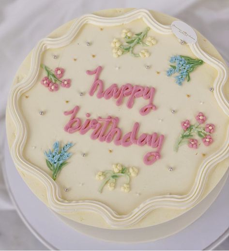 This cake has dainty little pastel flowers on a buttercream frosted cake with cursive wordings. Simplicity is beauty! Dainty Flower Cake, Piped Flower Cake, Frosted Cake, Simplicity Is Beauty, Baking Aesthetic, Buttercream Flower Cake, Buttercream Flower, Vintage Cakes, Cake Sizes