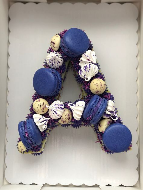 Cake shaped as the letter “A”. There are electric blue macarons, white meringues and white chocolate. There are also electric purple sprinkles. Letter A Cake, Letter Cake, Blue Cakes, Number Cakes, Gluten Free Treats, Letter A, Blue And Gold, A Letter, Electric Blue