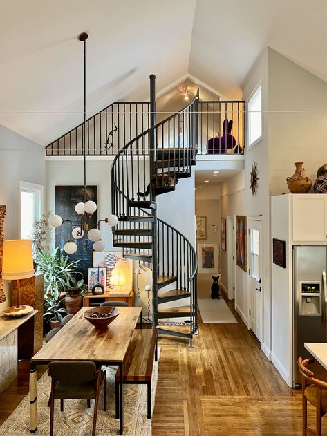 An open room with a spiral staircase leading upstairs and a long wooden dining table Sf Apartment, San Francisco Apartment, Vintage Apartment, House Smell Good, Vintage Credenza, Beautiful Sofas, House Smell, Casual Home, Spiral Staircase