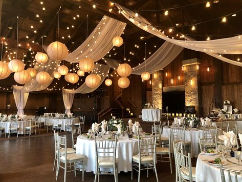 Rustic Hall Wedding Decor, Vintage Wedding Venues Rustic, Wedding Inside Decorations, Draped Fabric Wedding Decor, Wedding Reception Lanterns, Wedding Decorations Lanterns, Rustic Wedding Ceiling Decor, Wedding High Ceiling Decor, Wedding In A Gymnasium