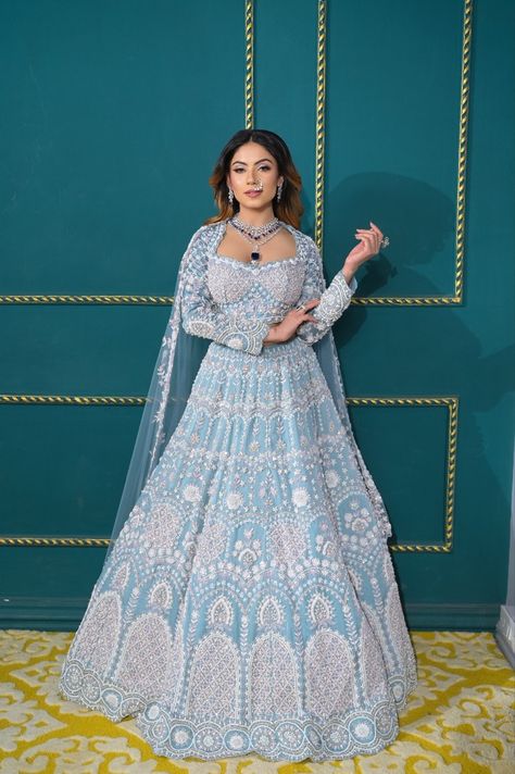 Crafted with intricate embroidery, the blue bridal lehenga often features a rich tapestry of threads, sequins, and zari work, creating an intricate, regal appearance. The lehenga’s silhouette typically combines luxurious fabrics like silk, satin, or velvet, which lend volume and grace to the design. Paired with a matching dupatta, this outfit can be adorned with delicate embellishments such as pearls, crystals, or gemstones, adding an extra layer of glamour. Sky Blue Bridal Lehenga, Sky Blue Lehenga Wedding, Lehenga Jewellery Ideas, Blue Bridal Lehenga, Sky Blue Lehenga, Lehenga Jewellery, Sky Blue Dress, Engagement Bride, Blue Lehenga