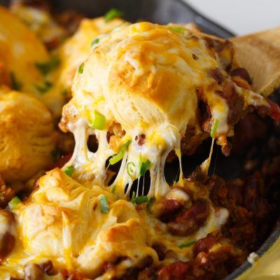 Pure comfort food is right here. Frito pie chili biscuit skillet has your name written all over it if you are looking for something that will stick to your ribs! Chili topped with fritos, cheese, and biscuits — what more could you ask for?! Frito Pie Chili, Flakey Biscuits, Frito Chili Pie, Cheesy Biscuit, Frito Pie, Frito Lay, Canned Biscuits, Quick Appetizers, Pan Meals