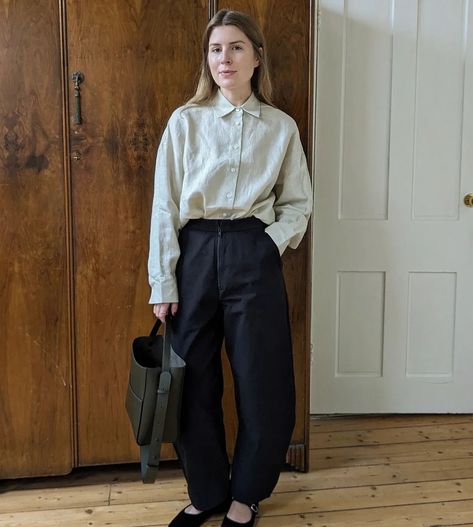 A woman stands in front of a wooden wardrobe. She wears black barrel leg trousers, black ballet flats, a button-up white shirt and carries a gen leather bag. Leg Trousers Outfit, Trousers Outfit, Trouser Outfit, Black Ballet, Black Ballet Flats, Oversized Shirt, Outfit Details, Wearing Black, Ballet Flats