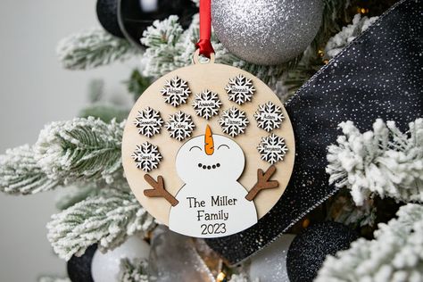 "Embrace the holiday season with our charming personalized snowman ornament, available in two heartwarming options. The 'Last Name' Family 2023 adorns the snowman's belly in the family version, while the grandkids version shares the sentiment 'Grandkids are like snowflakes. Each one is beautiful and unique. With space for up to 9 snowflakes, each personalized with a name, this 3D delight is sure to melt hearts. Crafted with two layers, the bottom layer in birch wood and the top layer featuring the snowman and snowflakes in MDF, it's a delightful addition to your holiday decor that celebrates the warmth of family and the uniqueness of each individual. Product Information: - Ornament Dimensions: 4.6\" tall by 4.25\" wide.  - Materials: This ornament is made from 2 layers. The bottom layer is Grandkids Christmas Ornaments, Snowman Family Ornament, Cricut Stocking Stuffers, Wood Burn Christmas Ornaments, Grandkids Ornaments, Wooden Ornament Ideas, Family Ornaments Personalized, Simple Christmas Gifts, Engraver Projects