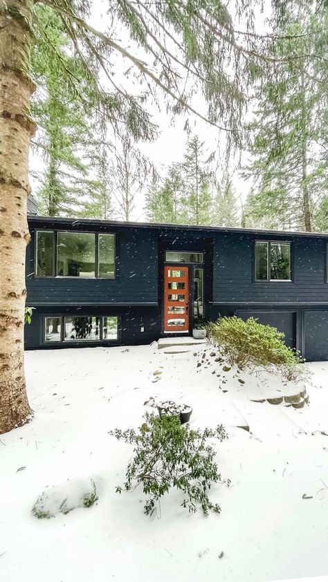 A black midcentury modern home set against a snowy and tree filled property. The Object Of My Affection, Black Home Exterior, Split Level House Exterior, Split Level Remodel Exterior, Split Level Exterior, Ireland Houses, Split Level Remodel, Mid Century Modern Exterior, Exterior House Remodel