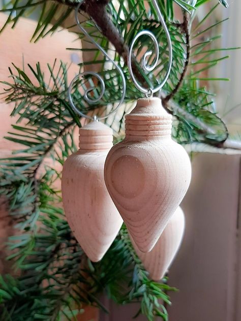 Add a touch of timeless elegance to your Christmas tree with these hand-turned wood ornaments, crafted in the shape of vintage light bulbs. Made from untreated natural pine wood, these ornaments are perfect for those who appreciate natural beauty or who enjoy DIY holiday projects. Each ornament can be painted, stained, or decorated to match your unique holiday theme, or left as is for a rustic, natural look. Available in sets of 3 or 5, each ornament is slightly different in shape and size, addi Wood Turned Ornaments Holidays, Wood Turned Projects, Turned Christmas Ornaments Wood, Wood Turning Christmas Ornaments, Wood Turning Projects For Beginners, Woodturned Ornaments, Turned Christmas Trees, Lathe Ornaments, Wood Lathe Projects