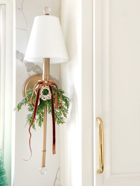 Beautiful White and brass kitchen sconce decorated for Christmas Brass Sconces, Ribbon On Christmas Tree, Christmas Inspo, Christmas Greenery, Wall Lighting, Holiday Inspiration, Christmas Ribbon, Christmas Bows, Dining Room Living Room