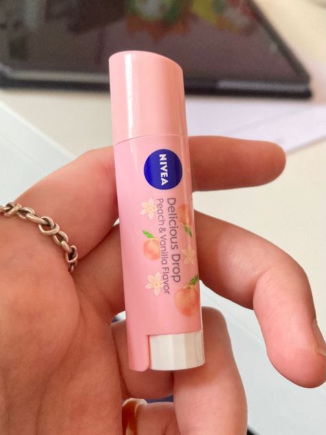 It's a delicious drop nivea lip balm. it's a pale peachy pink colour and has little vanilla flowers and peaches on it. It's being held in a white hand with a silver ring on it. Nivea Delicious Drop, Peach Perfume Aesthetic, Lip Balm Aesthetic, Nivea Lip Balm, Peach Lip Balm, Peach Jelly, Lip Jelly, Peach Lipstick, Cute Nail Polish