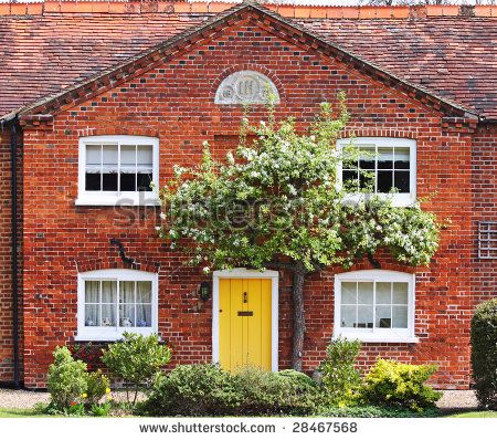 Quaint Red Brick English Village Cottage with tree in Spring Blossom Yellow Door On Brick House, Red Brick Yellow Door, Red Brick House Yellow Door, Red Brick Homes Exterior, Front Door Brick House, Yellow Front Door, Red Brick House Exterior, Village Cottage, Yellow Front Doors