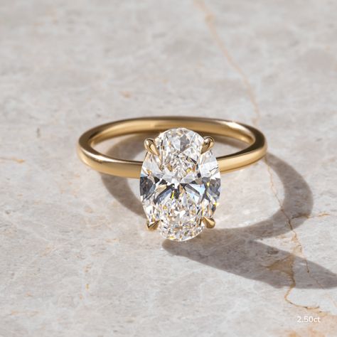 The Yellow Gold Solitaire Engagement Ring showcases a 2.50-carat oval lab-grown diamond, set on a classic yellow gold band. Its simple and radiant design makes it a stunning choice for any engagement. Handcrafted in Hatton Gardens, London. Tiffany Engagement Ring Gold, Yellow Gold Solitaire Engagement Ring, Dream Rings, Oval Moissanite Ring, Stacked Wedding Rings, Gold Solitaire Engagement Ring, Yellow Gold Solitaire, Yellow Diamond Rings, Moissanite Engagement Ring Oval