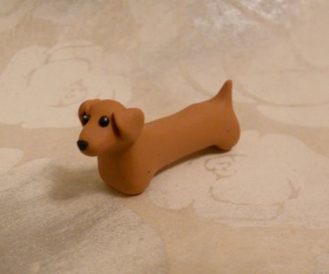 Doxie Desserts: This dachshund is handmade with FIMO and sold by GraceAndFlowers on Etsy. This simple shape could easily be recreated with fondant for use as a cake topper. Clay Sausage Dog, Clay Weiner Dog, Weiner Dog Clay, How To Make A Dog Out Of Clay, Polymer Clay Sausage Dog, How To Make A Clay Dog Easy, Polymer Clay Dachshund, Dachshund Clay Sculpture, Cute Clay Dog