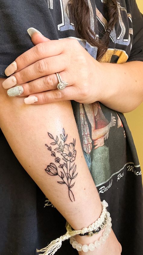 Black and gray simple wildflower tattoo on forearm Flower And Greenery Tattoo, Greenery Tattoos, Wild Flower Forearm Tattoo, Wildflower Wrap Around Arm Tattoo, Wildflower Bouquet Tattoo Forearm, Wild Flower Tattoo Back Of Arm, Wildflower Tattoo Forearm, Greenery Tattoo Sleeve, You Belong Among The Wildflowers Tattoo