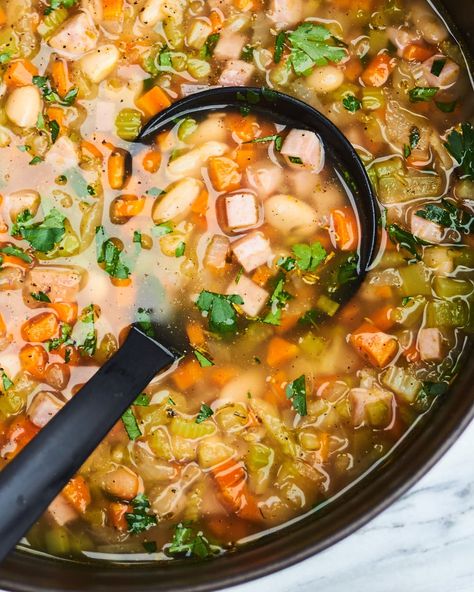 A ladle spoons the ham and bean soup from a dutch oven. Easy Ham And Bean Soup, Ham Bone Soup, Ham And Bean, Easter Ham, Bone Soup, Bean Soup Recipe, Easy Ham, Ham Steaks, Lunch Inspiration