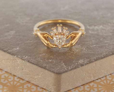 Exquisite and delicate Claddagh ring with Moissanite heart and baguette diamonds crown. Traditional Irish promise ring, a beautiful symbol of love (heart), friendship (hands) and loyalty (crown). The modernized design of this ring makes it a perfect heirloom piece of our days, that will become your real heritage. About this item: -Moissanite (~0,5ct) and diamonds G-H color.Total carat weight ~ 0.55 -Heart stone can be customized, please feel free to write to me for variations. -Solid 10K Rose, Y Claddagh Promise Ring, Rose Gold Claddagh Ring, Claughdaugh Engagement Ring, Modern Claddagh Ring, Sacred Heart Engagement Ring, Odd Engagement Rings, Symbolic Diamond Wedding Ring, Gem Rings Stones, Gold Heart Engagement Ring