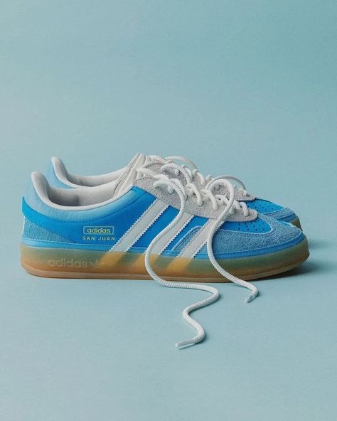 Bad Bunny × Adidas Gazelle Indoor "San Juan" A blend of creativity and cultural homage. Inspired by the blue skies and sunny beaches of Bad Bunny's hometown, this sneaker is a revamped and edgy version of the classic Gazelle. It features a 'Celestial Blue' leather base, overlaid with short-haired suede panels and canvas that add texture and depth. The toe box perforations allowing for airflow, perfect for those warmer days. Sneakers Smart Casual, Men's Boot Liners, Men's Adidas (men), Nike Shoes (men), Dream Closets, Adidas X, Clean Shoes, Bad Bunny, Shoe Closet