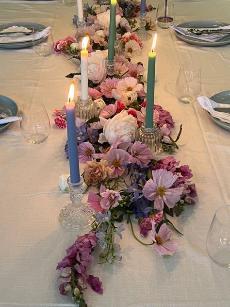 Pink purple blue pastel flower arrangement on dining table with candle sticks and blue ceramic dinner set for birthday dinner party Floral Party Table Decor, Flower Aesthetic Birthday Party, Flower Themed Party Aesthetic, Circle Table Set Up, 18th Birthday Flower Decorations, Flowers Laying On Table, Floral Dinner Table Setting, Dinner Party Table Settings Birthday, Flower Dinner Party Aesthetic