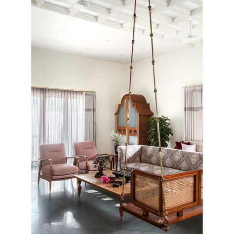 Living room ❤️ Modest yet elegant, this space had a seating arrangement and the quintessential swing was definitely a part of it ❤️ All teak furniture gave the space its warmth and a patterned fabric on the sofa imparted the ethnic appeal. The coffered ceiling with moulded and carved trims brought the space together into a cozy haven ❤️   #Studioipsa #interiordesignstudio #interiordesignideas #interiordesigninnovation #interiorstyling #traditionalhome #indianhomes Puja In Living Room, Ethnic Living Room, Puja Ghar, Wooden Pillars, Architecture Life, Indian Home Interior, Ethnic Home Decor, Pooja Room Design, Puja Room