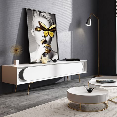 An edgy and modern piece that's simple in design, yet completely functional and seamless in any space,this TV console has it all. Rectangular frame pairs with unique oval sling door in white, this TV stand is sure to creat an eye-catching accent. And the sleek legs in gold is the icing on the cake. What's more, two slding doors provide plenty of storage space for your electronics, medicine and beyond. Made of MDF and stainless steel for strengh and durability, this piece is a great additon in yo White Tv Stand, White Tv Stands, Minimal Furniture, Console Tv, White Tv, Cardboard Sculpture, Gold Legs, Tv Room, Tv Unit