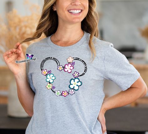 👉 Elevate your wardrobe with a touch of Disney magic! 🎀✨ Our soft shirt featuring the iconic Minnie Mouse silhouette adorned with vibrant hibiscus 🌸 flowers and glitter details is the perfect blend of cute and chic. Add a dash of sparkle to your day and let Minnie's timeless charm brighten every moment. Available now for a touch of Disney whimsy in your style! 👜 SHOP LINK in Bio: www.PersonalizedCraft.net #AffordableDisneyFashion #MinnieMouse #GlitterMagic #HibiscusFlowers #PersonalizedCra... Minnie Mouse Silhouette, Silhouette Head, Mouse Silhouette, Disney Tee, Disney Tees, Flower Shirt, Hibiscus Flowers, Crew Neck Shirt, Disney Style