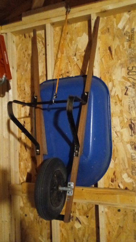 Garage Storage Lawn Mower, Mower Storage, Wheel Barrow Storage Ideas, How To Hang Wheelbarrow In Garage, Hang Wheelbarrow Garage Storage, Diy Shovel And Rake Storage, Shed Organization Ideas, Storing Shovels And Rakes In Garage, Wheelbarrow Storage