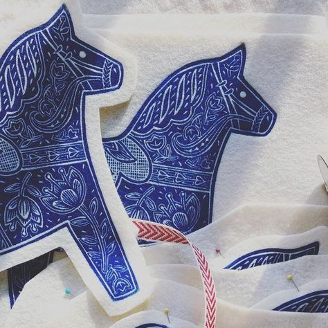 Andrea Wisnewski on Instagram: "These Dala Horses are linocuts printed on felt. They are in the process of being made into hanging ornaments. They make great little gifts for those on your list💙link in bio to purchase #linocut #linocutprint #linoprintersofinstagram #printmaking #printmakerspost #printmaker #printmakersofinstagram #printandpattern #printart #folkart #folkyeah #dala #dalahorse #ornament #makers #makersmovement #makersmarket #handmade #handsewn #felt #feltcraft #runningrabbitpress" Dala Horse, Faux Taxidermy, Lino Print, Linocut Prints, Xmas Cards, Taxidermy, Yule, Felt Crafts, Linocut