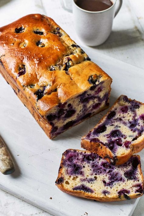 Cake cut into two slices showing blueberries inside sat on a white chopping board surrounded by a knife and a mug of tea Blueberry Lemon Yoghurt Cake, Blueberry Yoghurt Cake, Yoghurt Loaf Cake, Blueberry Cake Healthy, Gluten Free Blueberry Loaf, Healthy Loaf Cake, Healthy Yogurt Cake, Lemon And Blueberry Cake, Blueberry Loaf Cake