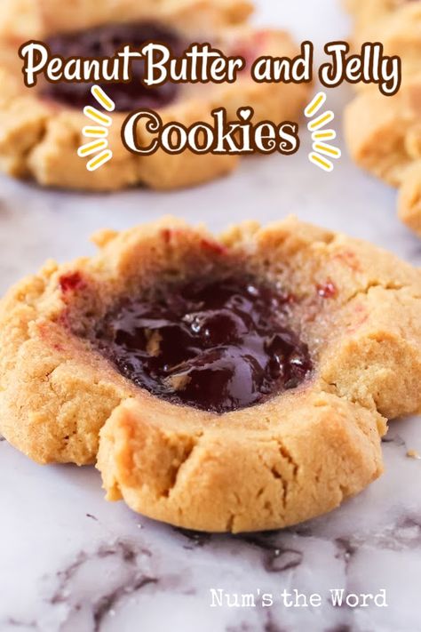 These Peanut Butter and Jelly Cookies are a mouthwatering delight that will transport you back to childhood. #peanutbuttercookies #peanutbutterandjellycookies #peanutbutterandjellycookies #peanutbutterjellycookiecompany #jellycookies #peanutbutterthumbprints #thumbprintcookies #numstheword #uniquecookies #uniquepeanutbuttercookies #christmascookies Peanut Butter And Jelly Cookies, Peanut Butter Jelly Brownies, Jelly Stuffed Peanut Butter Cookies, Peanut Butter And Jelly Sandwich Cookies, Jelly Filled Peanut Butter Cookies, Jelly Cookies, Strawberry Jelly, Unique Cookies, Cookie Company