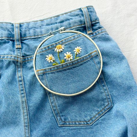 Created in collaboration with sustainable fashion brand Nobody's Child to help you love your clothes for longer. In this adorable embroidery kit, you will receive patterns for three graduating-sized patches of daisies. These versatile designs are the perfect way to add blooms to the pockets of your jeans, dress or a little embroidery on a casual blouse. In this design, you will learn some simple embroidery stitches from Satin Stitch to Leaf Stitch and the French Knot. This box contains all the p Embroidery Designs In Jeans, Embroidery Pocket Design, Jeans Pocket Embroidery, Jeans Embroidery Diy, Simple Embroidery Stitches, Leaf Stitch, Daisy Patches, Carbon Paper, Anchor Embroidery