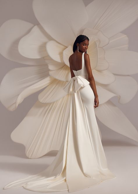 Bertie – strapped square neckline fitted dress with elongated skirt and a detachable wide ribbon bow on the back. Complemented with a transparent veil decorated with voluminous flowers on the edge. Simple White Wedding Dresses, Dress With A Bow On The Back, Wedding Dresses With A Bow, Fitted Wedding Gown With Bow, Wedding Dresses With Bow On Back, Proposal Dress Engagement, Wedding Dress With Bow On Back, Dress With Bow In The Back, Modern Wedding Dress Minimalist