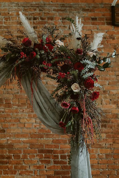 Sage Green December Wedding, Christmas Garland Wedding Arch, Forest Green And Dark Red Wedding, Wedding Arch Ideas Christmas, Christmas Wreath Arch Wedding, Jewel Tone Flower Arch, Forest Green And Red Wedding Theme, Sage Green Maroon Wedding, Emerald Green And Burgundy Wedding Flowers