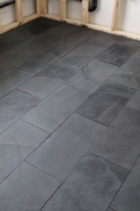 Dark Tile Bedroom Floor, Black Slate Bathroom Floor Master Bath, 12x24 Black Floor Tile Bathroom, Dark Basement Bathroom Ideas, Black Floor Tile Bathroom Ideas, Dark Grey Slate Tile Floor, Ways To Lay 12x24 Tile, Slate Tile Master Bath, Black Tile Brown Grout